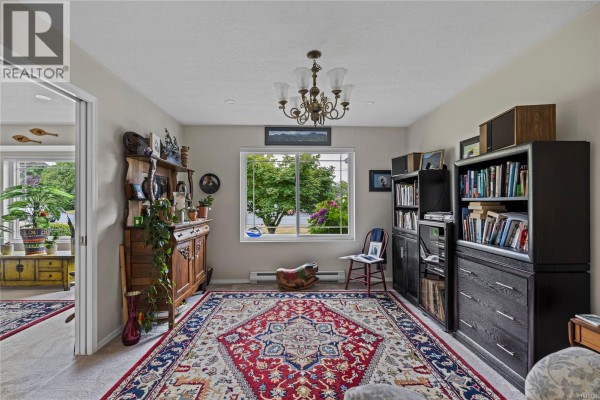 Study or den with a large window, built-in bookshelves, and antique wooden furniture. - 879 Aberdeen Dr, Parksville