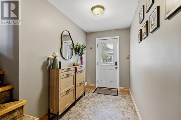 Interior entryway with light grey walls, wood shoe cabinet, and white door. - 88 Chambers Ave, Sault Ste  Marie