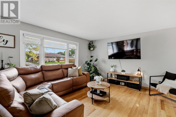 Living room featuring a sectional sofa, wood coffee table, and entertainment unit. - 88 Chambers Ave, Sault Ste  Marie