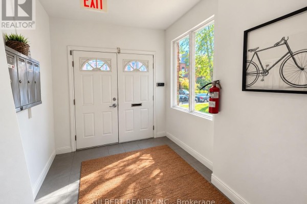 Interior foyer with double white doors, mailboxes, a bicycle artwork, and a fire extinguisher. - 88 Cowan Avenue, Toronto