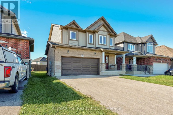 Side exterior view of a beige and brown two-story house with a double garage and green lawn. - 88 Davidson Drive, Stratford