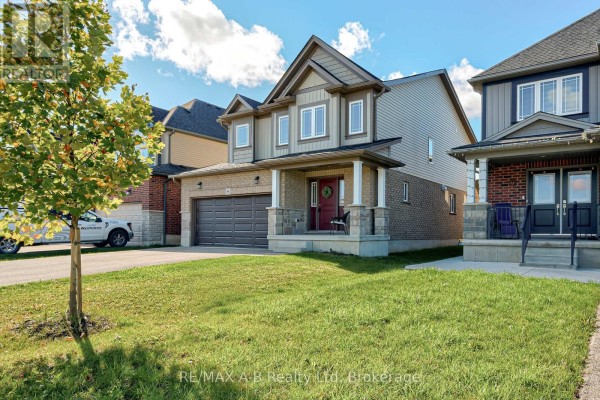 Side angle view of a two-story residential house showing the front entrance, garage, and adjacent homes. - 88 Davidson Drive, Stratford