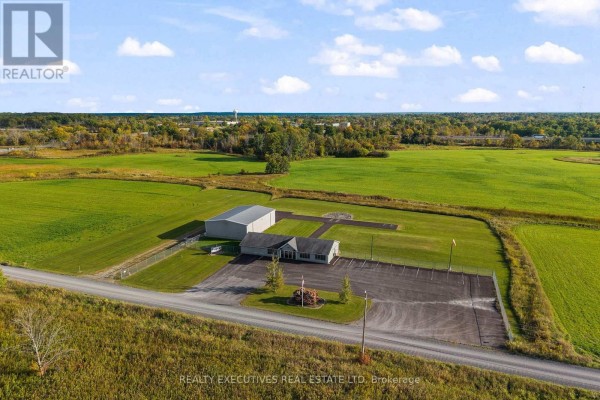 Angle view of commercial building and hangar with paved lot and fenced perimeter. - 88 Highway 32 Highway N, Front Of Leeds & Seeleys Bay