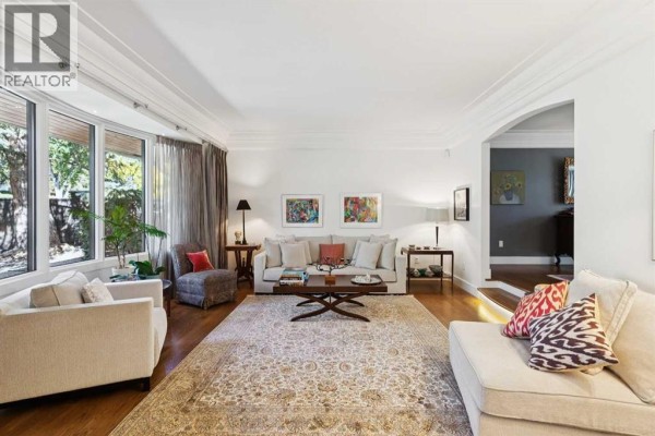 Living room with large windows, neutral-colored sofas, and a patterned rug. - 88 Massey Place Sw, Calgary