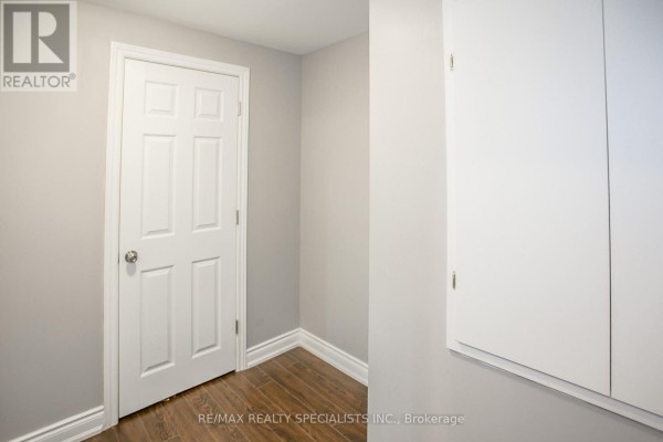 Interior hallway with two white paneled doors and white baseboards against light gray walls. - 88 Robert Parkinson Drive, Brampton