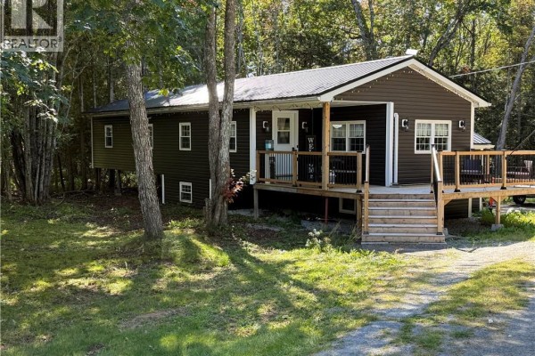 View of the dark brown bungalow's front entrance with a porch and wooden deck. - 883 Route 855, Midland