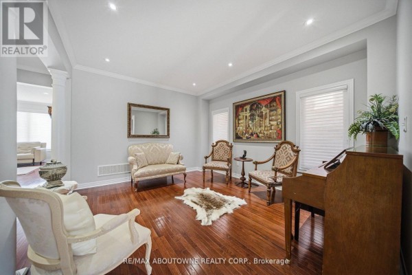Living room with hardwood floors, ornate furniture, large artwork, and a piano. - 884 Stoutt Crescent, Milton