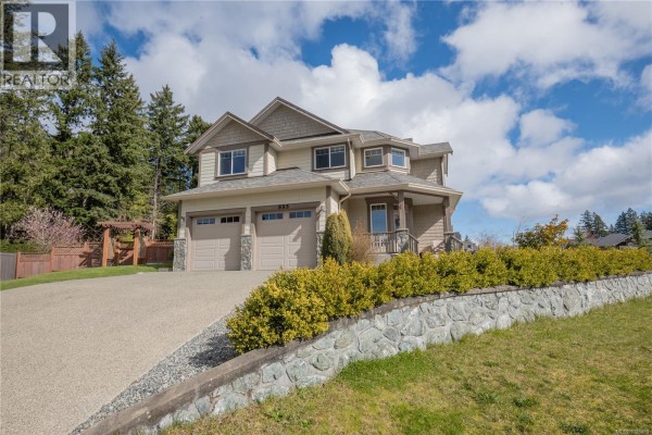 Open-concept living area with dark cabinetry, stainless steel appliances, and hardwood floors - 885 Pratt Rd, Mill Bay