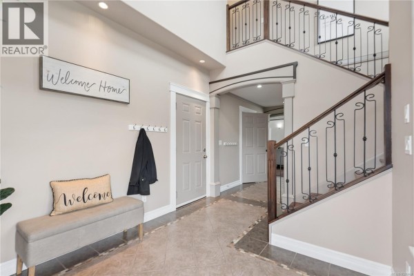 Cozy bedroom featuring a window, hardwood flooring, and green accent pillows - 885 Pratt Rd, Mill Bay