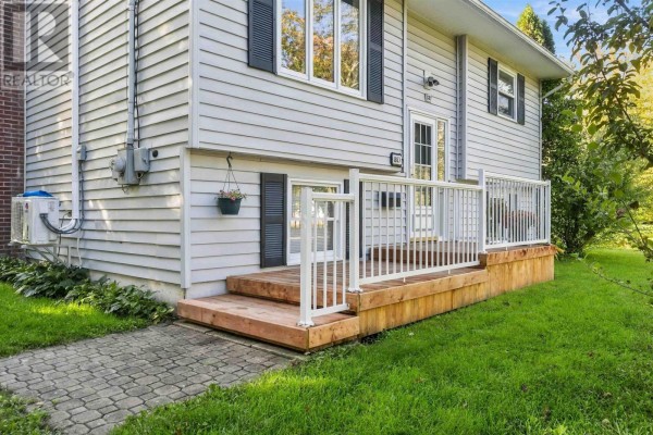 Close-up of the wooden deck and steps leading to the front door of the light grey house. - 887 Richard Street, Kentville