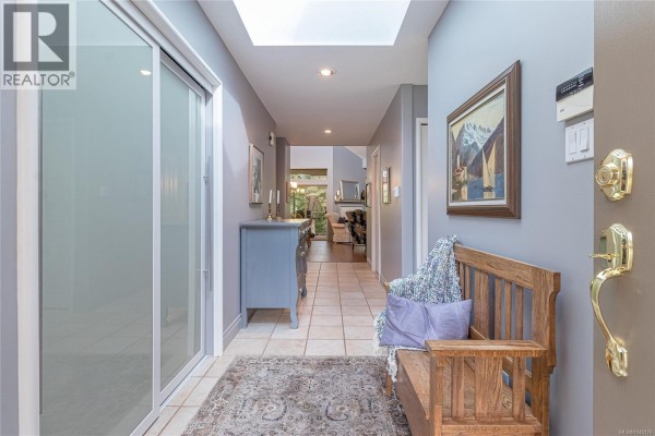 Interior entryway of a townhouse with tile floors, a wooden bench, and a view into the living area. - 888 Lakes Blvd, Parksville