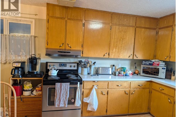 Kitchen with light wood cabinets, white countertops, and stainless steel appliances. - 8893 Holding Road, Adams Lake