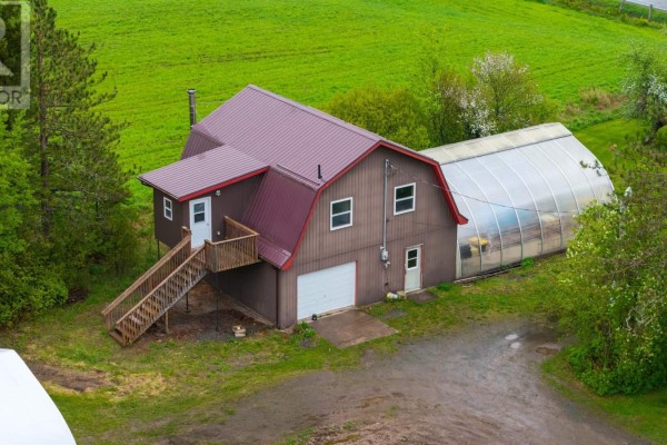 Basement with concrete floor, wood-paneled walls, and a large pile of firewood. - 8896 Highway 224, Greenwood