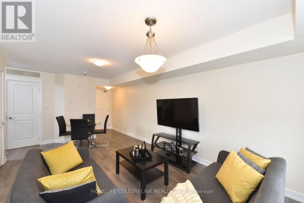 Combined living and dining area with sofas, dining set, and a large television, showing access to stairs. - 89 - 100 Parrotta Drive, Toronto