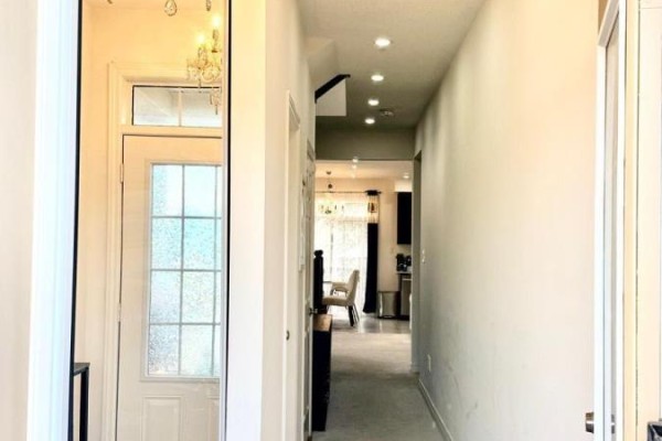 Interior hallway with mirrored closet doors, tile floor, and entryway beyond. - 89 Hartley Avenue, Brant