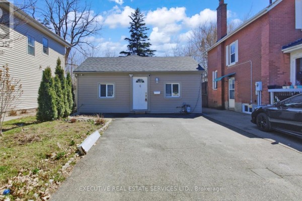 Single-story house with vinyl siding and paved driveway - 89 John Street Brampton