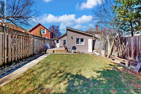 Backyard with wooden fence, deck, and shed - 89 John Street Brampton