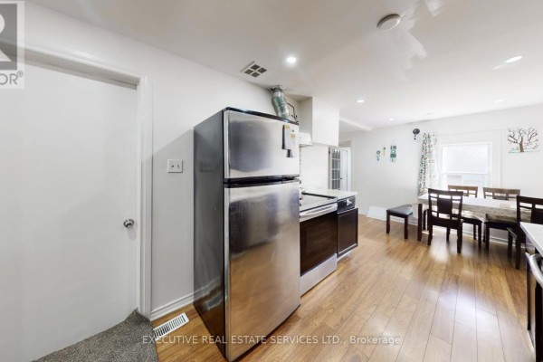 Stainless steel refrigerator and dining set in kitchen - 89 John Street Brampton