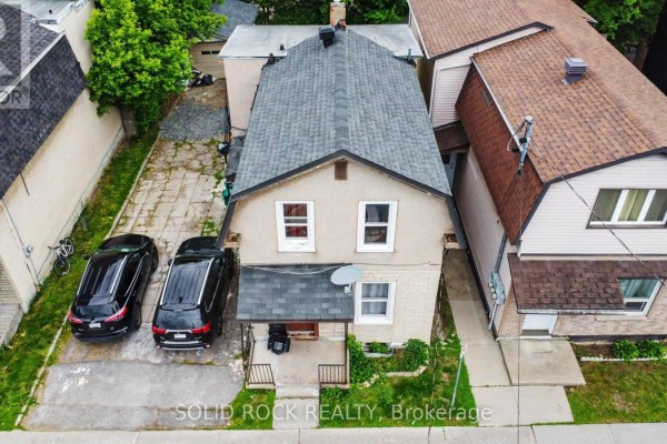 Front exterior of a two-story home with a pitched roof and two parked cars. - 89 Marier Avenue, Ottawa