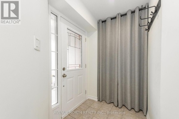 Foyer with a front door, side window, and a grey curtain partition. - 89 Silverlace Private, Ottawa