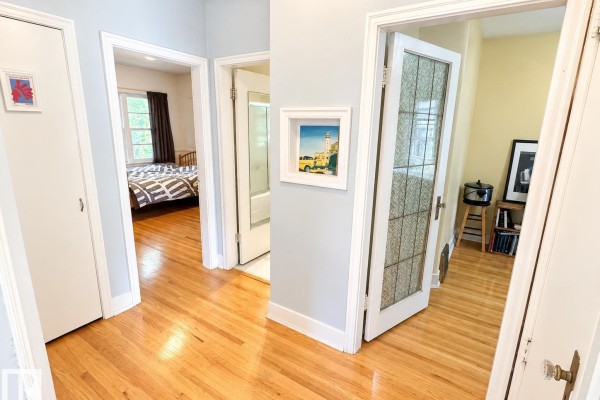 Hallway with doors to bedrooms and bathroom, hardwood floors. - 8907 83 Av Nw, Edmonton