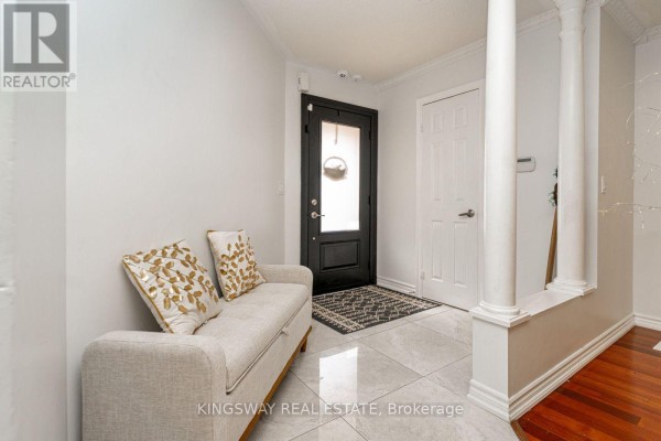 Wooden spiral staircase with carpeted treads and white doors in the foyer. - 891 Stonebridge Avenue, Mississauga