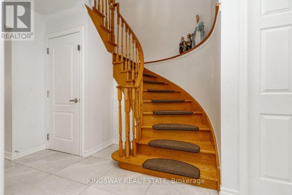 Interior view of the foyer showing a staircase, columns, and a sitting area. - 891 Stonebridge Avenue, Mississauga