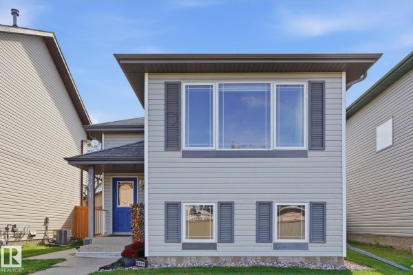 Front view of a two-story grey house with large windows on the upper level and shutters on the lower level. - 8911 173 Av Nw, Edmonton