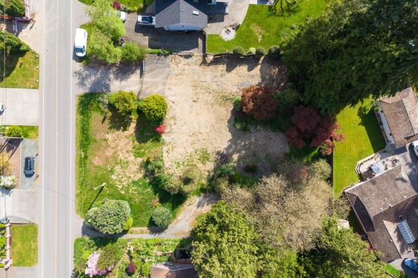 Top-down view of a bare lot with surrounding vegetation and houses. - 8917 Nash Street, Langley