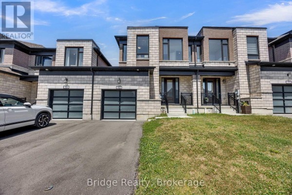 Street view of townhouses featuring stone and brick exteriors and glass garage doors. - 892 Sobeski Avenue, Woodstock