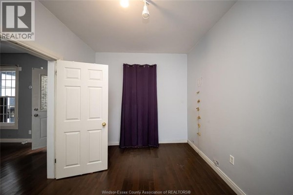 Dark hardwood floors, white door, and purple curtain - 894 University Avenue Windsor