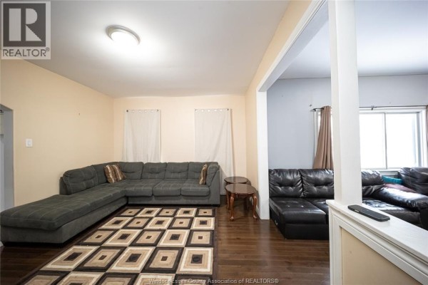 Living room with sectional sofas, patterned rug, and wood floors - 894 University Avenue Windsor