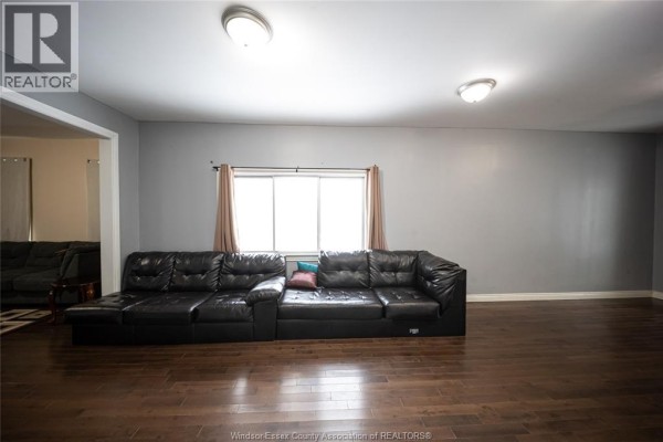 Black sectional sofa and hardwood floors in living room - 894 University Avenue Windsor