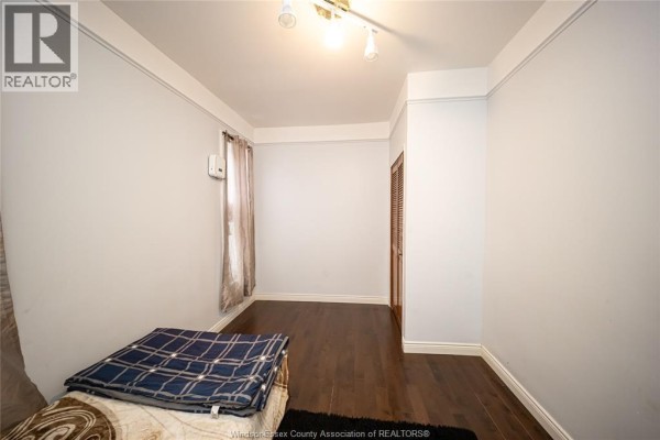 Bedroom with hardwood floors, track lighting, and a closet door - 894 University Avenue Windsor