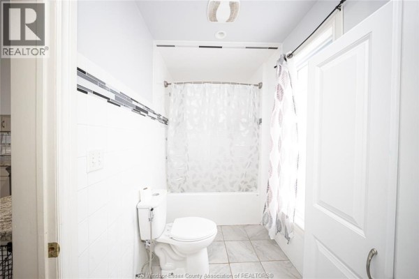 Bathroom with toilet, bathtub, and decorative tile - 894 University Avenue Windsor