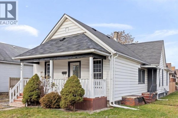 White house with covered porch and dormer window - 894 University Avenue Windsor