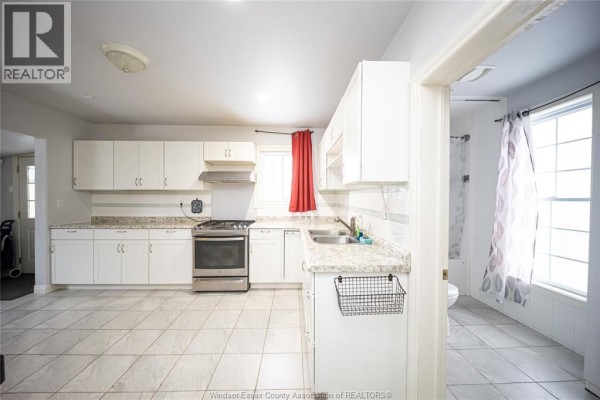 Kitchen with white cabinets, granite countertops, and stainless steel stove - 894 University Avenue Windsor