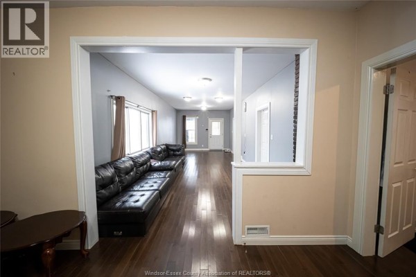 Living room with sectional sofa and hardwood floors, open to hallway - 894 University Avenue Windsor