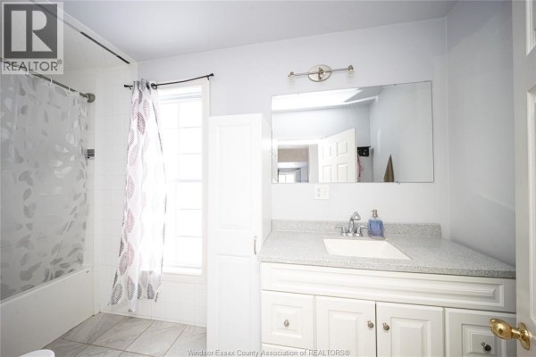 Bathroom with vanity, granite countertop, large mirror, and bathtub - 894 University Avenue Windsor
