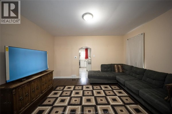 White kitchen with white cabinets, granite countertops, stainless steel gas stove, and tile floor. - 894 University Avenue, Windsor