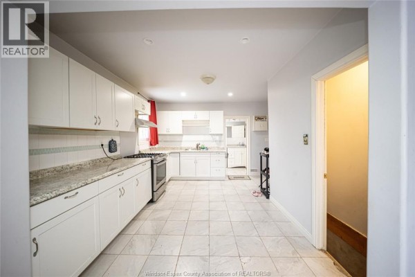Kitchen with white cabinets, granite countertops, and tile floor - 894 University Avenue Windsor
