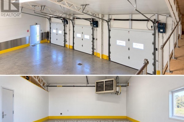 Interior view of a warehouse space with four overhead garage doors, white walls, and yellow floor markings. - 896 Cecile Boulevard, Hawkesbury