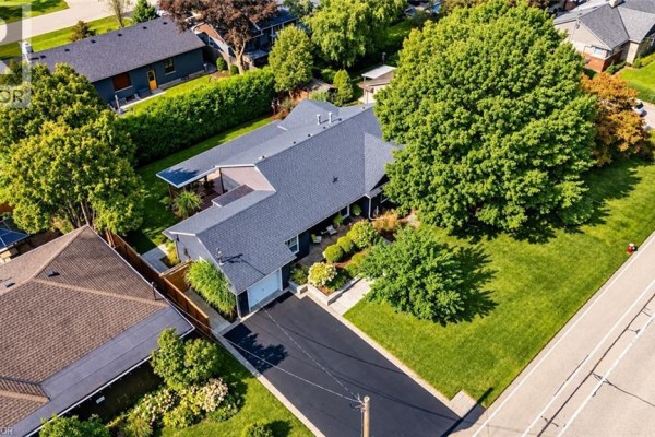 Aerial view of a dark grey bungalow with a dark roof, surrounded by trees and neighbouring houses. - 896 Eagle Drive, Burlington