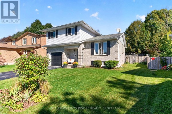 Side view of the house showing a lawn, fence, and neighboring properties. - 896 Mona Drive, Kingston