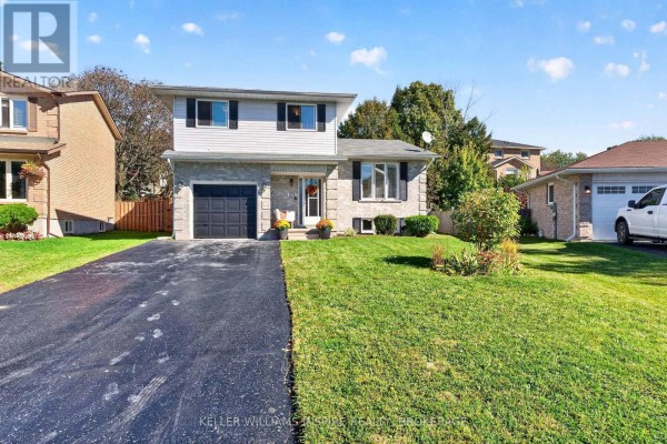The house at 896 Mona Drive with a black asphalt driveway and manicured lawn. - 896 Mona Drive, Kingston