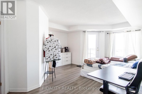 Bedroom with a bed, dresser, closet, and a door leading to a balcony. - 8a - 310 Central Park Drive, Ottawa