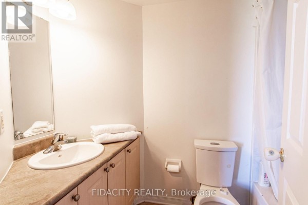 Bathroom with a vanity, sink, toilet, and a bathtub with a shower curtain. - 8a - 310 Central Park Drive, Ottawa
