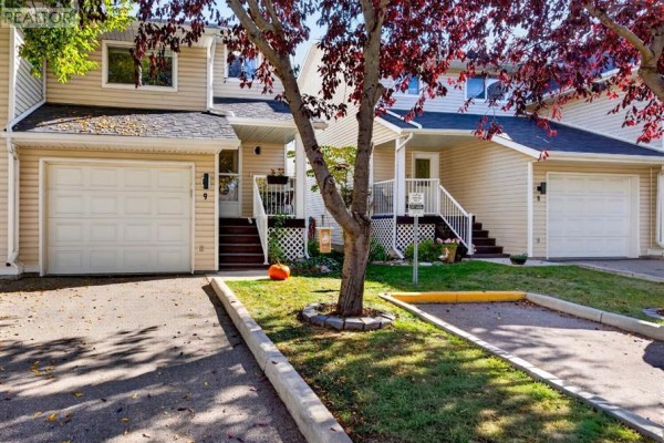 Front exterior view of townhouse with attached garage and front entrance steps. - 9, 567 Edmonton Trail Ne, Airdrie