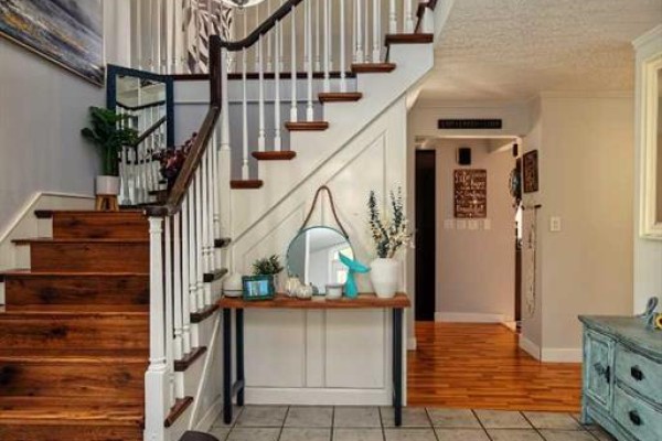 A wooden staircase with white railings and spindles leads upstairs from a tiled entryway with a console table. - 9, 710072 40 Highway, Rural Grande Prairie No  1, County Of