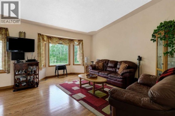 Bedroom with a double bed, nightstand, dark wood floor, and gray walls. - 9, 712051 Range Road 54, Rural Grande Prairie No  1, County Of